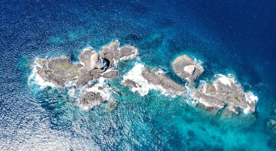 Top-down aerial view of the Catalina Islands volcanic rock formations surrounded by turquoise Pacific waters, Guanacaste, Costa Rica.