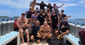 Group of volunteers and local police with collected trash bags at a beach cleanup in Playa Potrero, Costa Rica