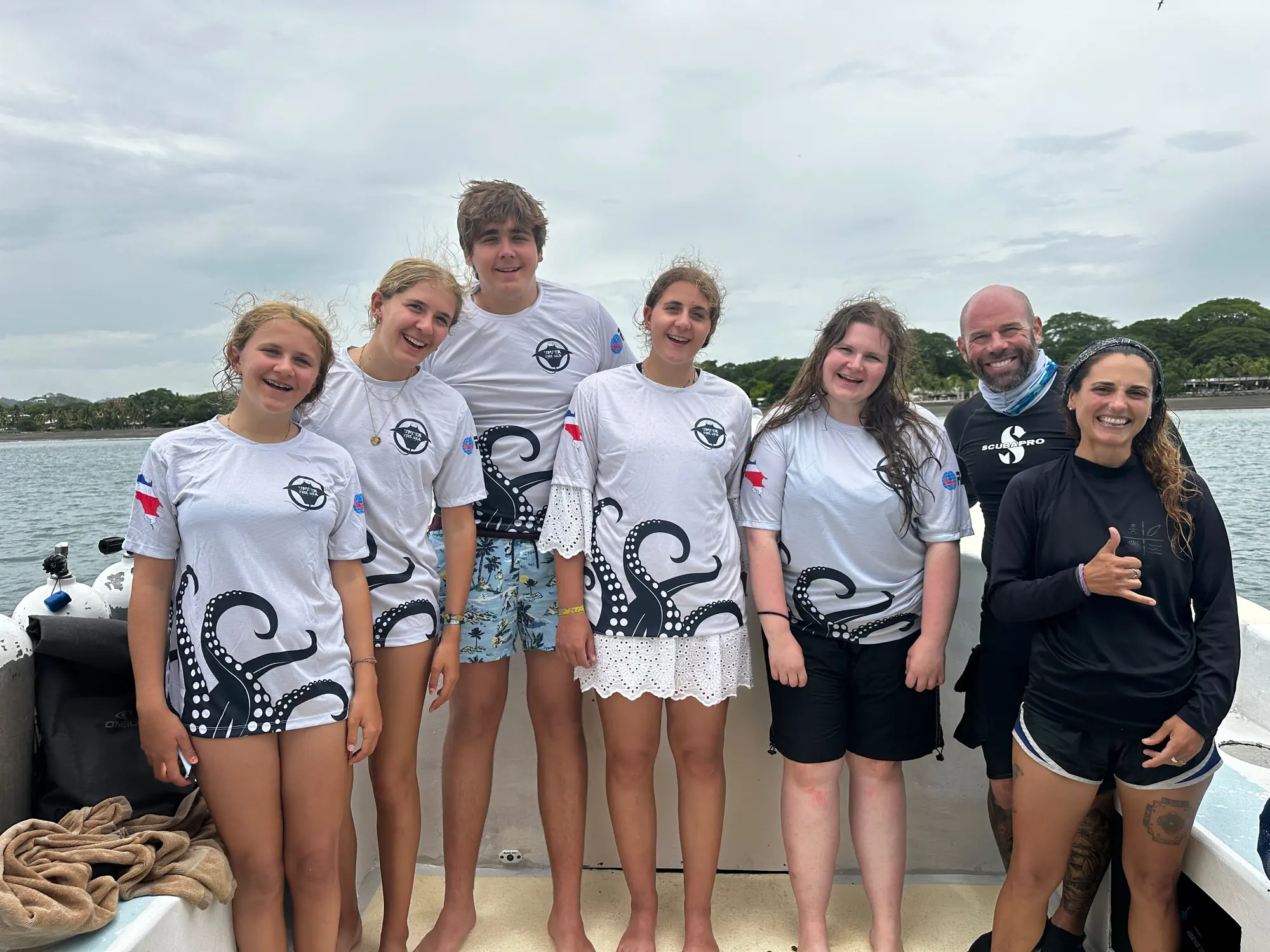 Six newly certified PADI Open Water divers with their instructors aboard the dive boat in Guanacaste, Costa Rica